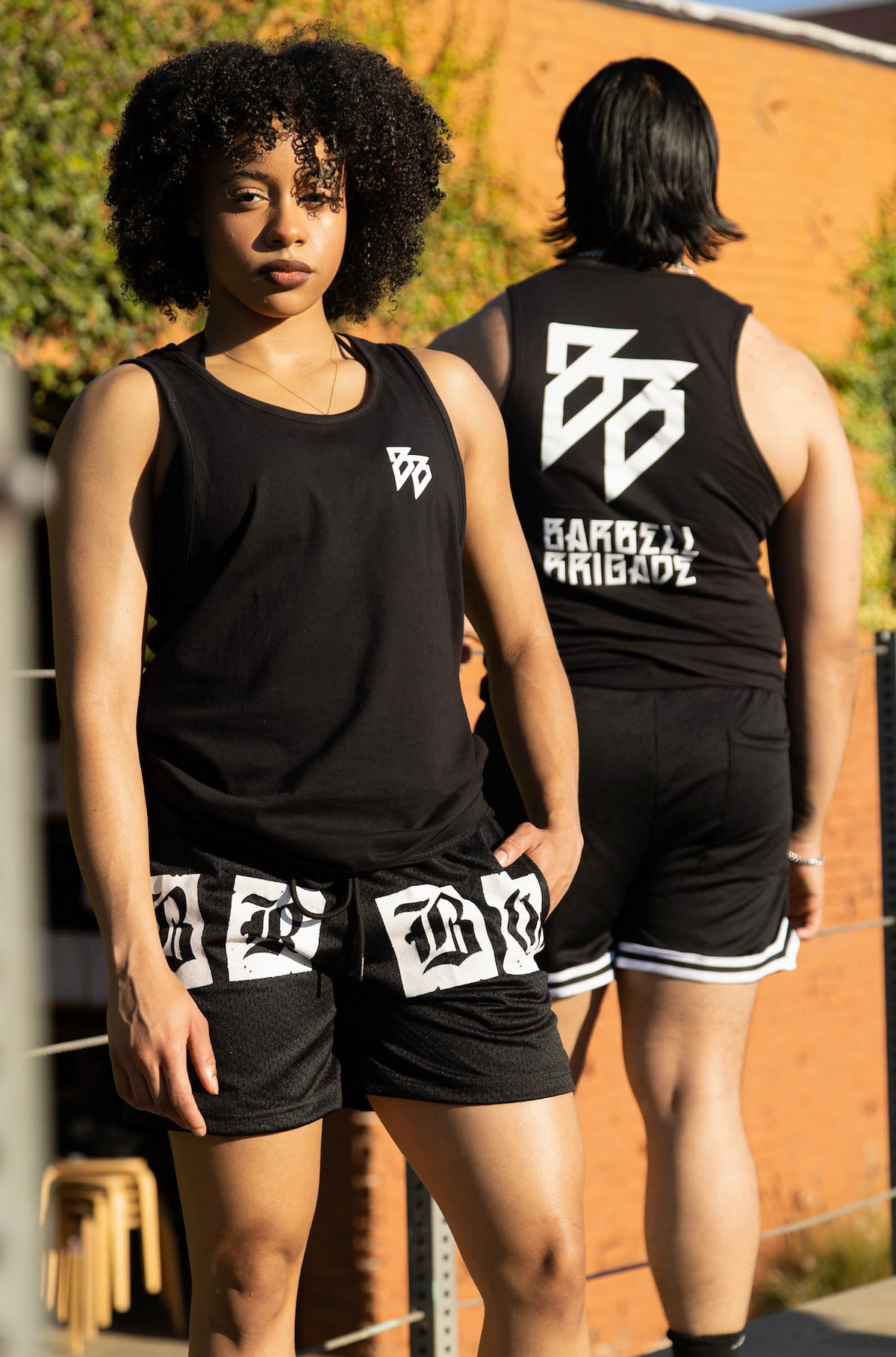 Two lifters wearing the BB Stack Tank in black